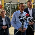 Morawiecki przed siedzibą KARR: miliony dla „swoich” zamiast dla powodzian. Rozwój Plus zapowiada kontrole